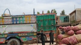 Truckers and their assistants wait in Jalalabad's heat as produce is loaded onto trucks headed across the border into Pakistan, May 16, 2012. (Bethany Matta/VOA)