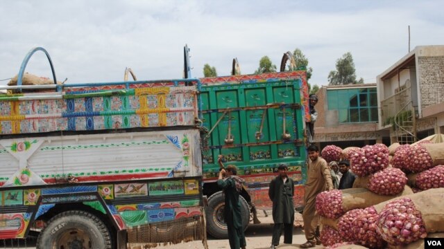 Truckers and their assistants wait in Jalalabad's heat as produce is loaded onto trucks headed across the border into Pakistan, May 16, 2012. (Bethany Matta/VOA)