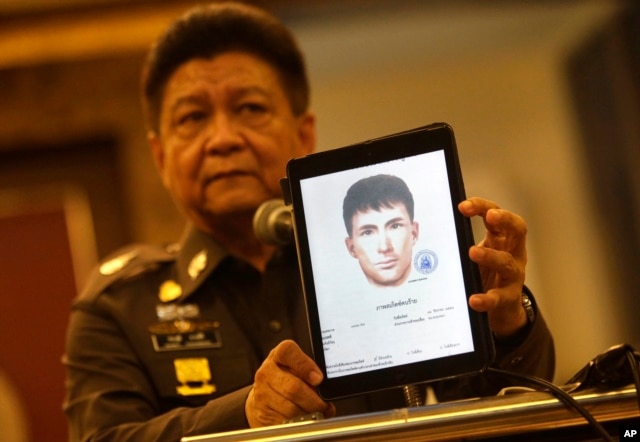 Police spokesman Lt. Gen. Prawuth Thavornsiri shows a photo of one of three men Thai authorities have issued new arrest warrants for in connection with the bombing case, in Bangkok, Thailand, Sept. 1, 2015.