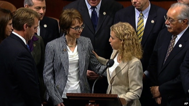 This video image provided by House Television shows Rep. Gabrielle Giffords, D-Ariz., accompanied by Democratic National Committee Chair Rep. Debbie Wasserman Schultz, D-Fla., walks  on the floor of the House on Capitol Hill in Washington, Wednesday, Jan.