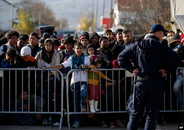 FILE - Migrants wait to register with police at a refugee center in the southern Serbian town of Presevo, Nov. 16, 2015.