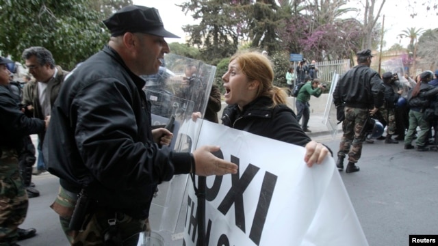 A protester tries to pass a police cordon during a rally by bank employees in Nicosia, Mar. 21, 2013.