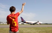 A young soccer fan waves to the plane carrying the Belgian soccer team, departing from Brussels airport to Sao Paulo, in Brussels, Tuesday, June 10, 2014. Belgium will play against South Korea, Russia and Algeria in Group H of the World Cup 2014 in Brazil. (AP Photo/Yves Logghe)