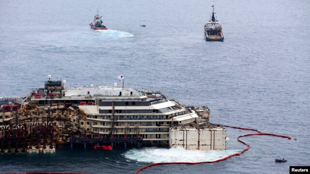 Các công nhân nâng chiếc du thuyền Costa Concordia lên tại cảng Giglio, ngày 14/7/2014.