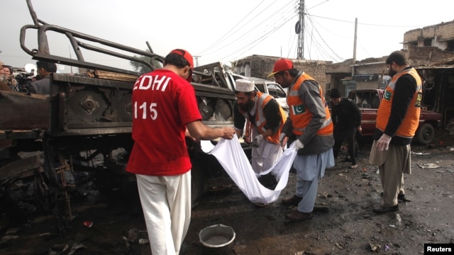 Rescue workers collect body parts after a bomb attack at Fauji Market in Peshawar, December 17, 2012.