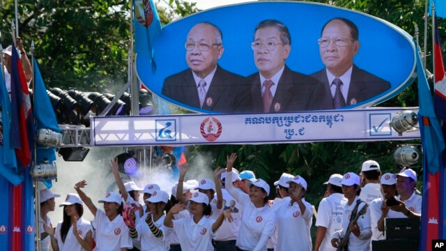 Người ủng hộ Thủ tướng Hun Sen và đảng Nhân dân đứng dưới chân dung các lãnh đạo đảng. Từ trái: Chea Sim, Thủ tướng Hun Sen và ông Heng Samrin trong một chiến dịch tranh cử tại Phnom Penh.