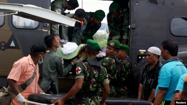 Para prajurit mengeluarkan jenasah prajurit korban serangan kelompok sipil bersenjata, setibanya di bandara Sentani, Papua (22/2/2013)
