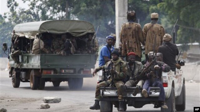 Soldiers loyal to Alassane Ouattara head off for battle as they deploy from a checkpoint at one of the principal entrances to Abidjan, Ivory Coast, Wednesday, April 6, 2011.