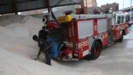 Para petugas pemadam kebakaran di kota New York menyiapkan garam di truk mereka untuk mengantisipasi datangnya badai salju (8/2).