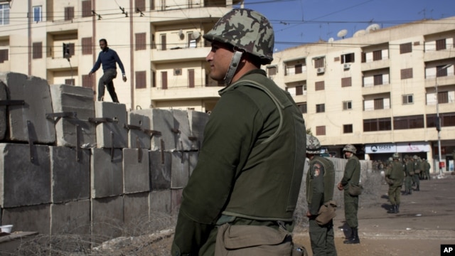 Egyptian army soldiers stand guard in front of the presidential palace, in Cairo, December 9, 2012.