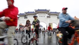 People cycle their bicycles at the Chiang Kai-shek Memorial Hall in Taipei December 31, 2011.