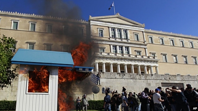 A Presidential guard box set alight by protesters at the unknown soldier monument burns during clashes outside the Greek Parliament, October 19, 2011.