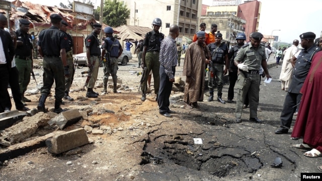 Security officials assess the scene of a suspected Boko Haram bomb attack that killed four people in Nigeria's northern city of Kaduna, April 8, 2012. 