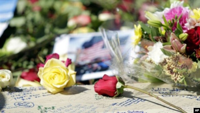 Family members of the victims of 9/11 write notes and leave flowers while they gather around the Ground Zero reflecting pool at the site where the twin towers once stood on the ninth anniversary of the terrorist attacks on the World Trade Center, in New Y