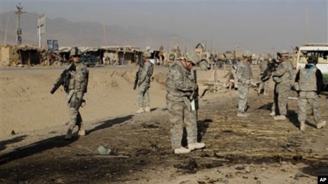 US soldiers inspect the site of suicide attack in Kandahar, Afghanistan, Saturday, Dec. 18, 2010.