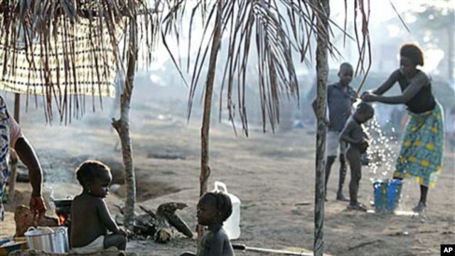 Children sit outside their family's tent as a neighbor bathes her son in a camp housing more than 2,600 Ivorian refugees, with more arriving daily, in Solo Town, near Zwedrou, Liberia, May 2011. (file photo)