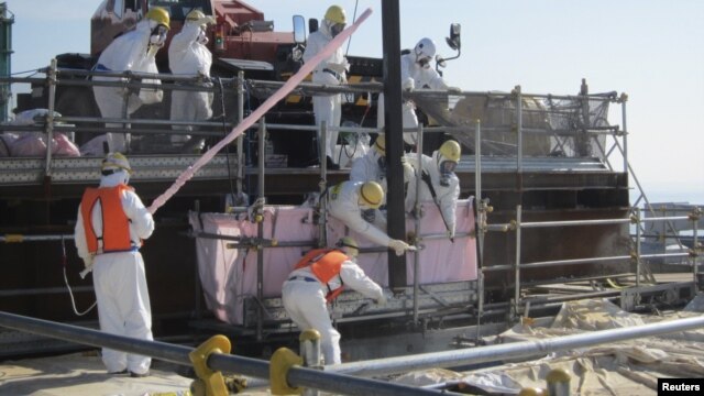 Workers are trying to remove unused nuclear fuel assemblies stored in the spent fuel pool tsunami-crippled Fukushima Daiichi Nuclear Power Plant No. 4 reactor building, July 19, 2012.