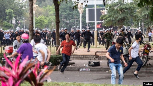 Cảnh sát chống bạo động rượt đuổi người biểu tình chống dự án xây nhà máy hóa chất ở Mậu Danh, tỉnh Quảng Đông, ngày 31/3/2014.