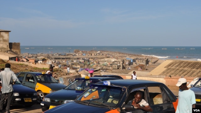 Taxis drivers wait for passengers near an beachfront slum in Accra's Jamestown (VOA/Laura Burke, Sept 2012).