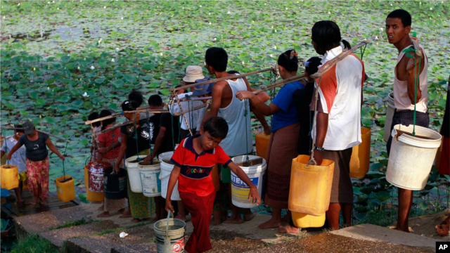 In this photo taken on April 21, 2012, local residents line up to fetch drinking water from a lake in Rangoon, Burma. (AP Photo)