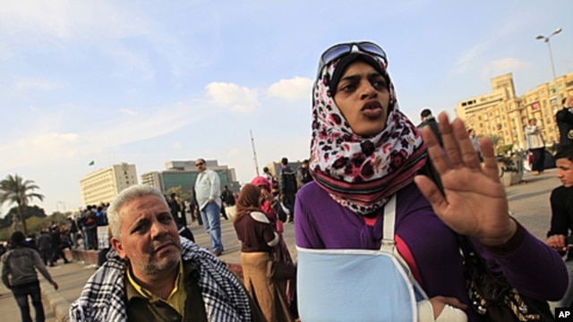A female Egyptian protester wearing a sling to support her arm, describes how she was hit by Egyptian army soldiers, during a demonstration against the military regime, at Tahrir Square in central Cairo, December 21, 2011.
