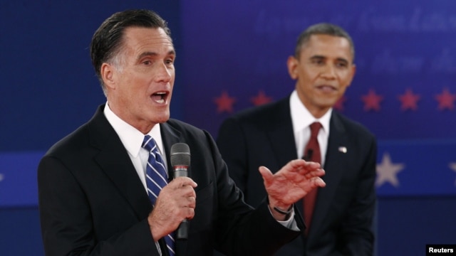 U.S. Republican presidential nominee Mitt Romney (L) answers a question as U.S. President Barack Obama looks on during the second U.S. presidential campaign debate in Hempstead, New York, October 16, 2012. 