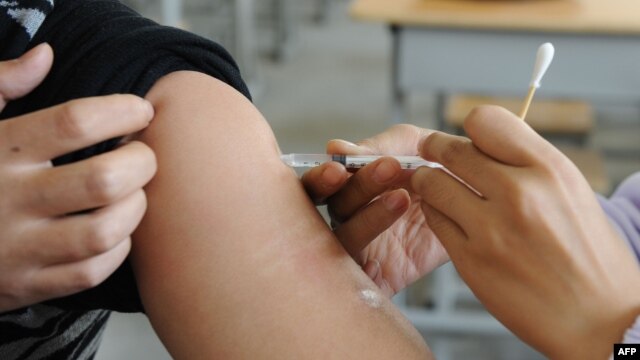 FILE - A Chinese nurse inoculates a man at a hospital in Hefei, east China's Anhui province, Nov. 10, 2009. China has vowed to tighten its regulation of locally-made vaccines to ensure their usefulness, after a recent scandal exposed regulatory loopholes.
