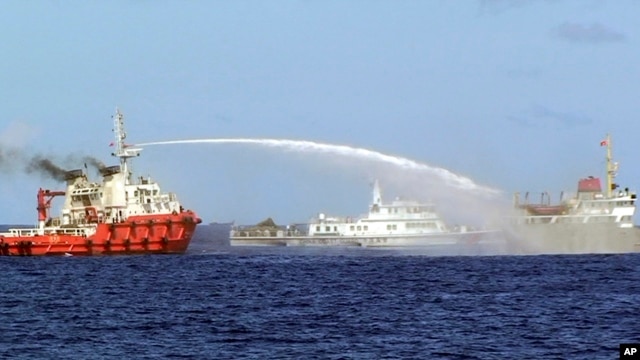 Một chiếc tàu của lực lượng tuần duyên Trung Quốc (trái) phun vòi rồng vào một tàu của Việt Nam hôm 7/5/2014, nhằm ngăn chặn tàu này tiến tới một giàn khoan dầu khổng lồ của Bắc Kinh ở nơi Hà Nội tuyên bố là thềm lục địa của mình.