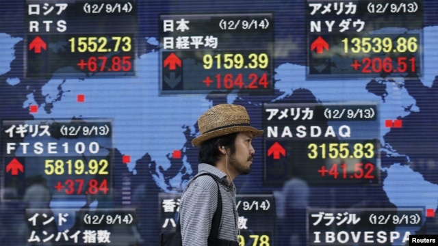 A man walks past a stock quotation board outside a brokerage in Tokyo, Japan, September 14, 2012. 