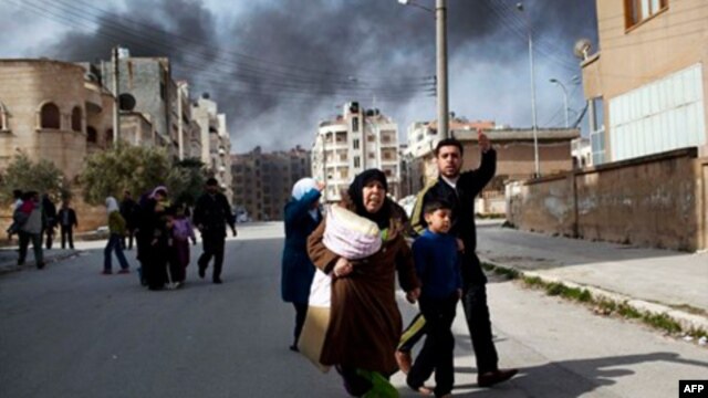 A family escapes from fierce fighting between Free Syrian Army fighters and government troops in Idlib on Saturday