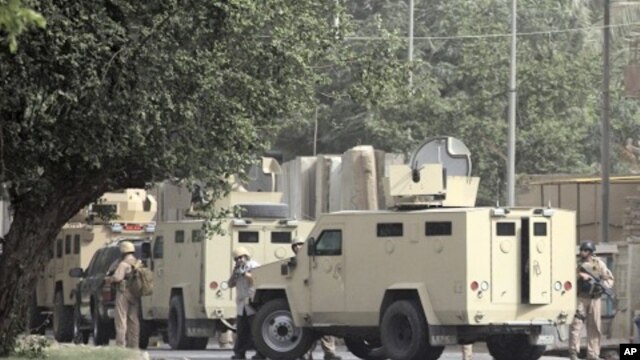 Private security personnel stand guard at the site of a bomb attack in Baghdad June 6, 2011.