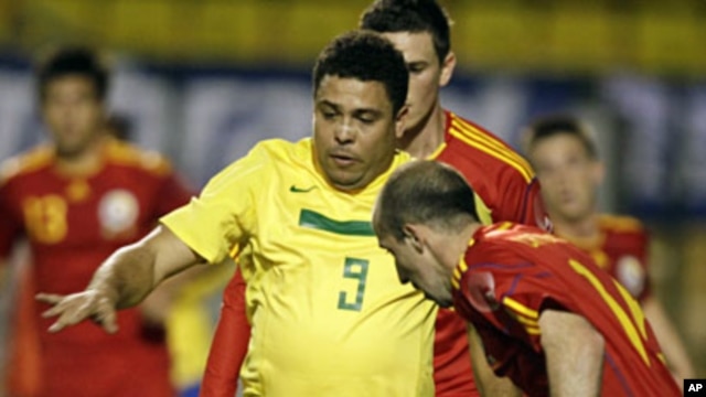 Brazil's retired striker Ronaldo (L) fights for a ball with Romania's Iasmin Latovlevici during his farewell soccer match with the Brazilian team, a friendly with Romania, in Sao Paulo, June 7, 2011