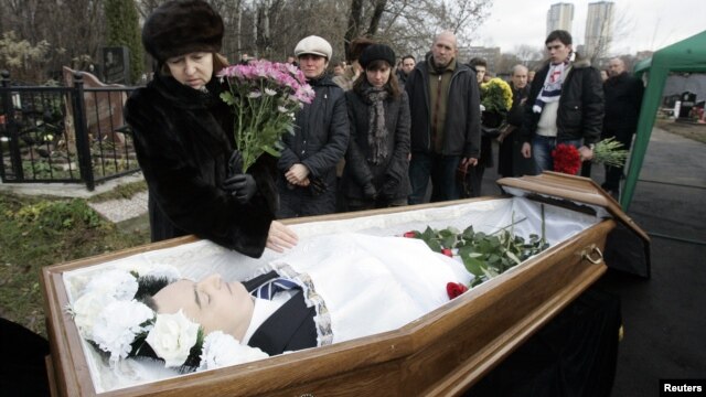 Nataliya Magnitskaya (L), mother of Sergei Magnitsky, grieves over her son 's body during his funeral at a cemetery in Moscow November 20, 2009.
