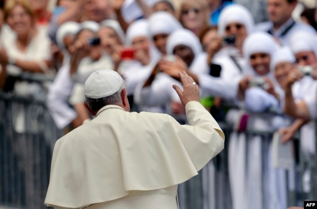 FILE - Pope Francis waves to nuns at the end of his weekly general audience in St Peter's square at the Vatican on September 17, 2014.