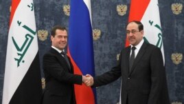 Russian Prime Minister Dmitry Medvedev shakes hands with Iraq's Prime Minister Nouri Al-Maliki outside Moscow, October 9, 2012.