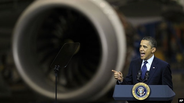 President Barack Obama speaks, Friday, Feb. 17, 2012, next to an airplane engine at the Boeing Company's 787 airplane assembly facility in Everett, Washington.