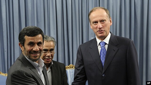 Iranian President Mahmoud Ahmadinejad, left, welcomes Russia's Security Council Secretary Nikolai Patrushev for their meeting at the presidency office, in Tehran, Iran, August 16, 2011