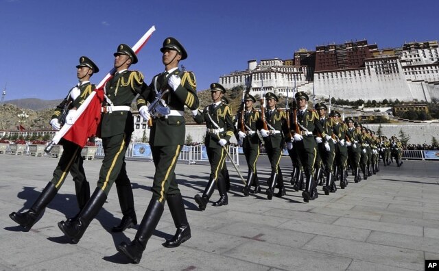 In this photo taken October 1, 2011, Chinese paramilitary police march during a flag raising ceremony near Potala Palace in Lhasa in northwestern China's Tibet province.