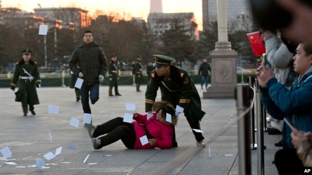 Cảnh sát Trung Quốc đè một người biểu tình xuống đất tại khu vực bị phong tỏa ở Quảng trường Thiên An Môn.