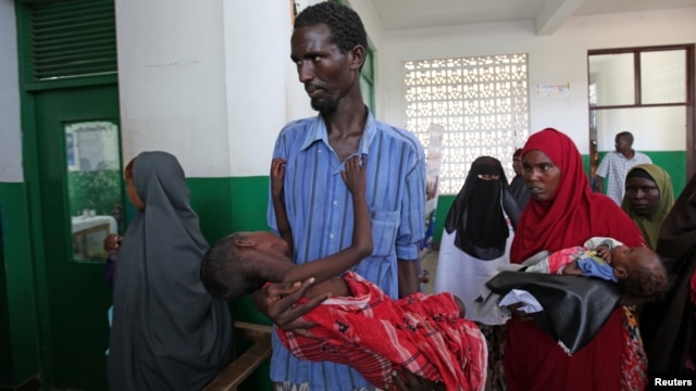 Internally displaced man carries cholera-stricken son through pediatric ward, Banadir hospital, Mogadishu, Aug. 25, 2011.
