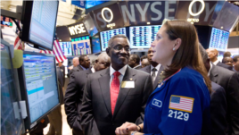 John Evans Atta Mills, the President of Ghana, visits the floor of the New York Stock Exchange, Dec. 15, 2011, and talks with specialist Jennifer Klesaris. 