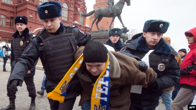 Police officers detain a protester in central Manezhnaya Square in Moscow,  on March 2, 2014, during an unsanctioned rally against the Russia's military actions in Crimea. 