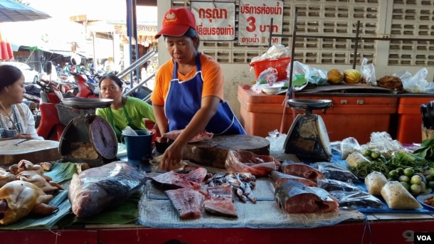 A fish merchant cuts up fish at a local market in Chiang Khan town, Thailand, July 25, 2016. (Neou Vannarin/VOA Khmer)
