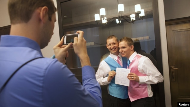 Mark Massey (C) and Dale Frost (R) pose for a picture after registering their marriage at the City Clerk's Office in New York, October 11, 2012.