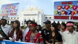Clad in traditional attire, activists march during a rally to end the fighting in northern Burma, in downtown Rangoon, Tuesday, January 1, 2013.