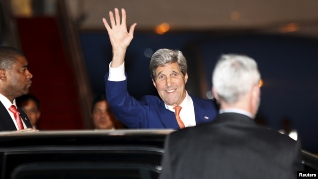 Ngoại trưởng John Kerry vẫy chào các nhà báo sau khi đặt chân tới sân bay quốc tế Phnom Penh hôm 25/1. 