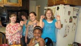 Madison Blandford (far left) and her classmates and neighbors show off their Ugandan beads at Madison's recent jewelry party (VOA/F. Elmasry)