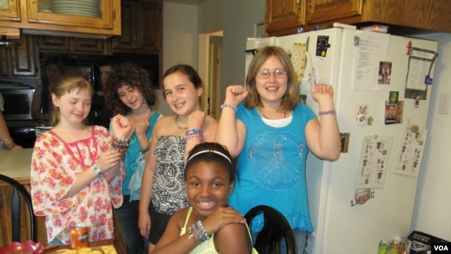 Madison Blandford (far left) and her classmates and neighbors show off their Ugandan beads at Madison's recent jewelry party. (VOA/F. Elmasry)