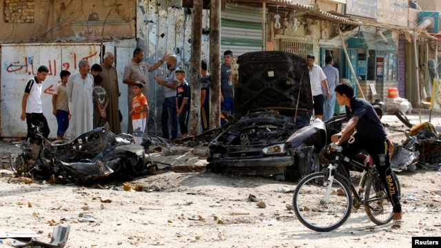 Civilians gather at site of a car bombing in Baghdad's Husseiniya district, June 25, 2013.