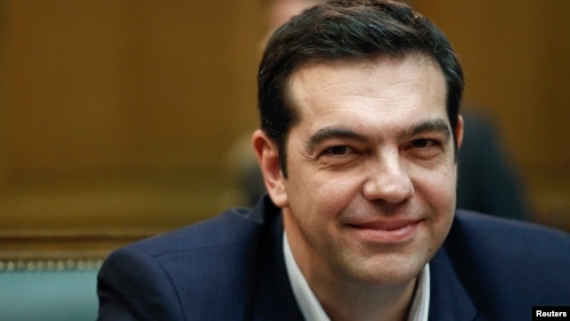 O primeiro-ministro grego Alexis Tsipras sorri como ele atende a primeira reunião do novo gabinete no edifício do parlamento em Atenas, 28 de janeiro de 2015.